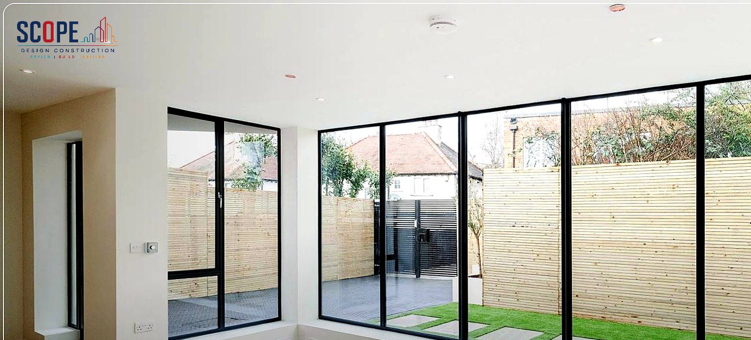 Bright finished interior with full-height glazing overlooking landscaped garden